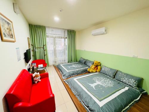 1 dormitorio con sofá rojo y silla roja en Qianshun Homestay en Xingang