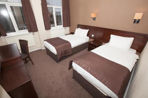 a hotel room with two beds and two windows at Dolphin SA1 in Swansea