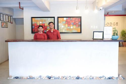 two men standing behind a counter in a room at Ialodge in Ormoc