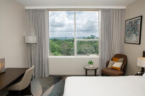 Habitación de hotel con cama y ventana en Royal Pacific Hotel, en Sídney