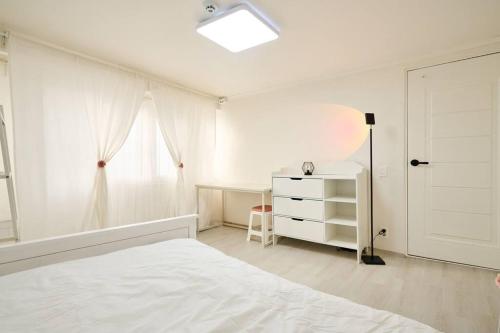 a white bedroom with a bed and a desk at 3 rooms, Hongdae, Shinchon unshared Villa in Seoul