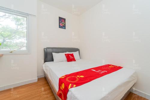 una camera da letto con un letto con una coperta rossa sopra di RedLiving Apartemen Aeropolis - Ivan Tower AR1 a Tangerang