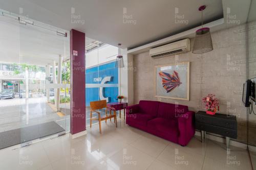 un soggiorno con un divano viola e un tavolo di RedLiving Apartemen Aeropolis - Ivan Tower AR1 a Tangerang