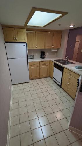 a kitchen with a white refrigerator and a tile floor at The Kimball at Temple Square in Salt Lake City