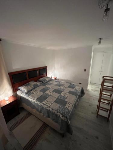 um quarto com uma cama e duas mesas e uma cadeira em Cómodo, relajante e ideal em Concón