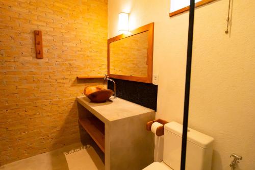 a bathroom with a sink and a toilet and a mirror at Vila Marina in Arraial d'Ajuda