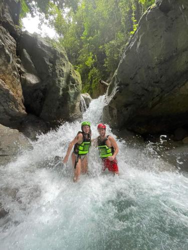 two people are standing in the water on a river at House of TamSe Laagans ' Inn in Badian