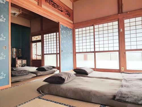 a room with three beds in it with windows at INASHIKI NEST in Inashiki