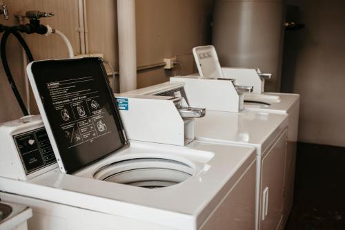 a white washing machine in a room with machines at Colonial Motel Richmond in Richmond