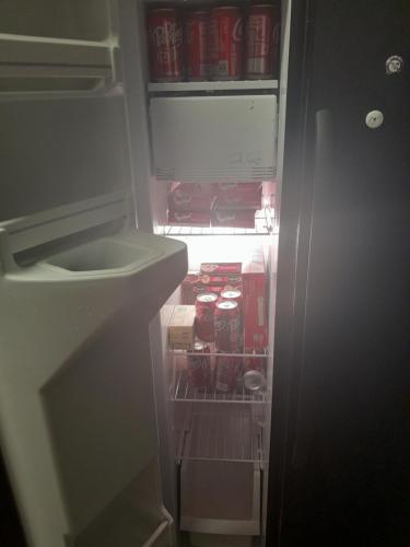 an open refrigerator filled with drinks and soda at Hethos in Austin