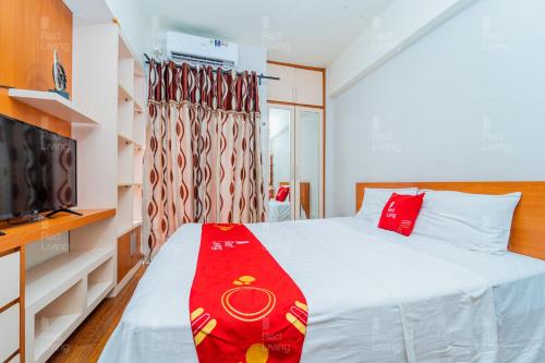 a small bedroom with a bed and a tv at RedLiving Apartemen Serpong Green View - Nawawih Room Tower B in Tangerang