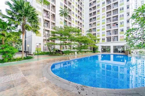 - une piscine au milieu d'un bâtiment dans l'établissement RedLiving Apartemen Serpong Green View - Nawawih Room Tower B, à Tangerang
