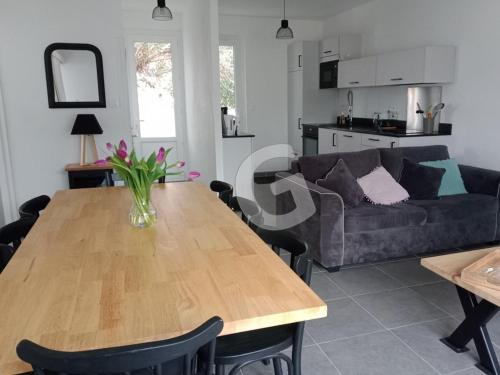un salon avec une table en bois et un canapé dans l'établissement Maison proche mer pour 8 personnes avec terrasse, proche commerces et activités, La Tranche-sur-Mer - FR-1-357-297, à La Tranche-sur-Mer
