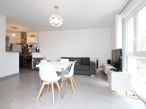 un salon avec une table et des chaises blanches dans l'établissement Appartement T2 avec Terrasse, proche Thermes, garage et Wifi - Balaruc-les-Bains - FR-1-553-182, à Balaruc-les-Bains