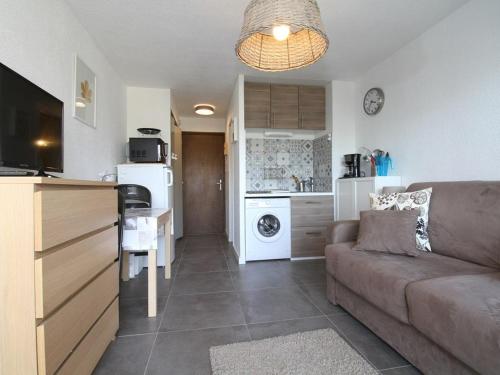 un salon avec un canapé et une cuisine dans l'établissement Charmant studio rénové avec grande terrasse, climatisation, parking privé, proche commerces et Thermes - FR-1-553-192, à Balaruc-les-Bains