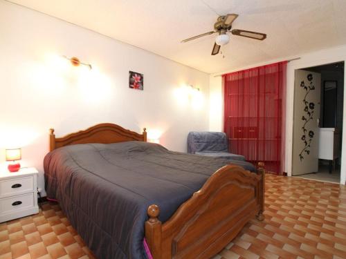 - une chambre avec un lit, une chaise et un ventilateur de plafond dans l'établissement Spacieux T2 rénové proche étang de Thau, climatisé, terrasse, parking, WiFi à 800m des thermes - FR-1-553-207, à Balaruc-les-Bains