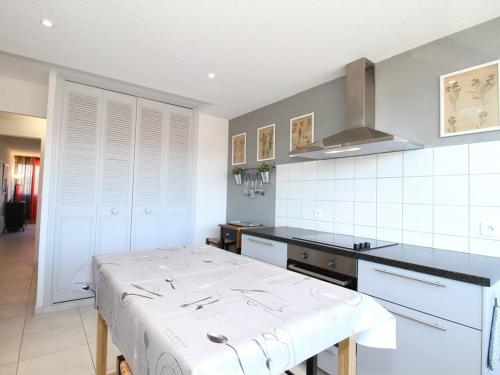 une cuisine avec une table au milieu dans l'établissement Appartement 3 pièces moderne à Balaruc-les-Bains avec garage privé, internet et équipements complets - FR-1-553-191, à Balaruc-les-Bains