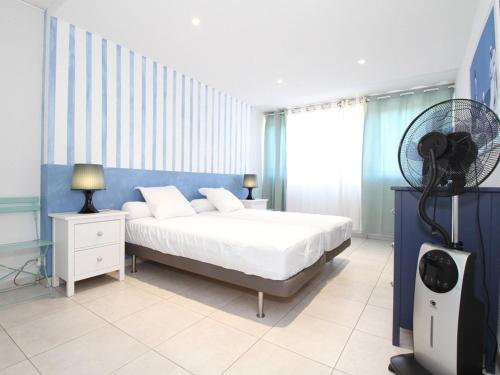 - une chambre avec un lit blanc et un ventilateur dans l'établissement Appartement 3 pièces moderne à Balaruc-les-Bains avec garage privé, internet et équipements complets - FR-1-553-191, à Balaruc-les-Bains