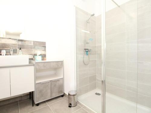 a white bathroom with a shower and a sink at Appartement T2 avec balcon, parking privé, wifi - Balaruc-les-Bains - FR-1-553-204 in Balaruc-les-Bains