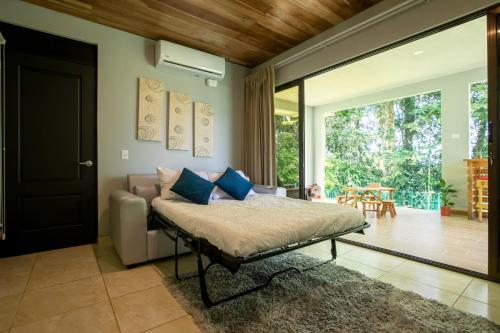 a bedroom with a bed and a sliding glass door at River Paradise Villa in Fortuna