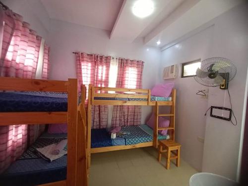 a room with two bunk beds and a fan at Bahai Jujai Resort in Baler