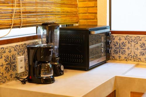 a kitchen counter with a coffee maker and a microwave at Vila Marina in Arraial d'Ajuda