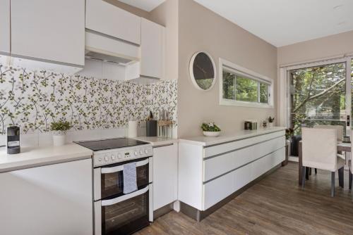 uma cozinha com armários brancos e um forno com placa de fogão em GLEN22R1 - Inner Glen em Sidney