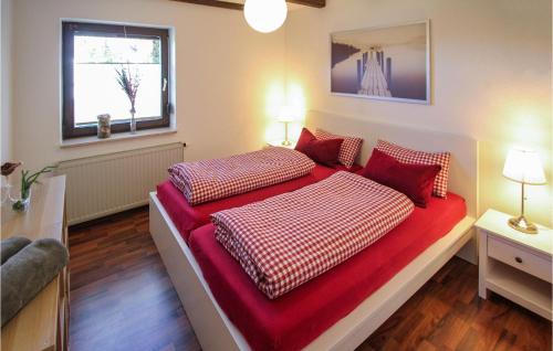 1 Schlafzimmer mit 2 Betten mit roter Bettwäsche und einem Fenster in der Unterkunft 2 Bedroom Cozy Apartment In Arrach in Arrach