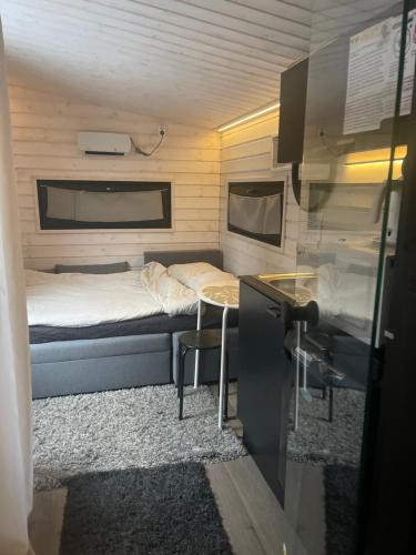 圖爾庫的住宿－Saunallinen vierasmaja 1 km Föriltä Aurajoelta，小房间,配有一张床和一张桌子