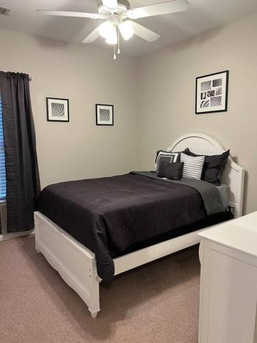Schlafzimmer mit einem Bett und einem Deckenventilator in der Unterkunft Cheerful 3 bedroom, close to downtown and arena!!! in Savannah
