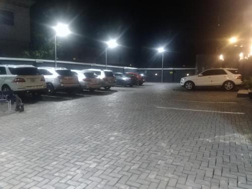 a parking lot with a bunch of parked cars at night at Kawruky Hotel Benin in Benin City