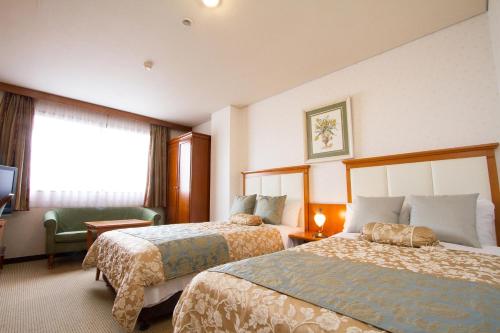 a hotel room with two beds and a window at Shohakuen Hotel in Kitakyushu