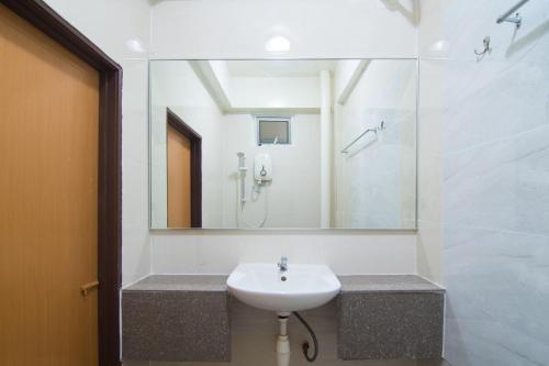 ein Bad mit einem Waschbecken, einer Dusche und einem Spiegel in der Unterkunft OYO 528 Andaman Sea Hotel in Batu Feringgi