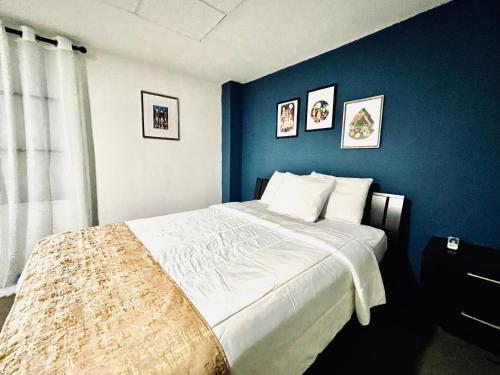 a bedroom with a large bed with a blue wall at SJ SUITES HOTEL in San Juan