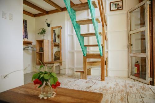 a room with a staircase and a vase of flowers on a table at Hygge Siargao in General Luna