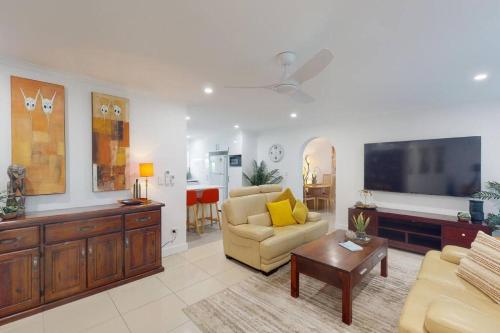 ein Wohnzimmer mit einem Sofa und einem TV in der Unterkunft Lotus Landing - A place to relax in Caboolture
