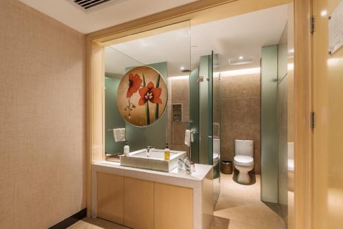 Paco Hotel Suyuan Metro Guangzhou في قوانغتشو: حمام مع حوض ومرآة