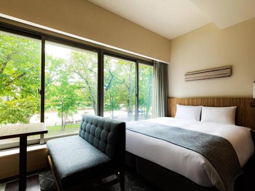 a bedroom with a bed and a large window at Sapporo View Hotel Odori Park in Sapporo