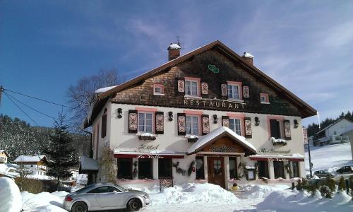 ein Gebäude mit einem davor geparkt in der Unterkunft Hôtel La Vallée in Xonrupt-Longemer