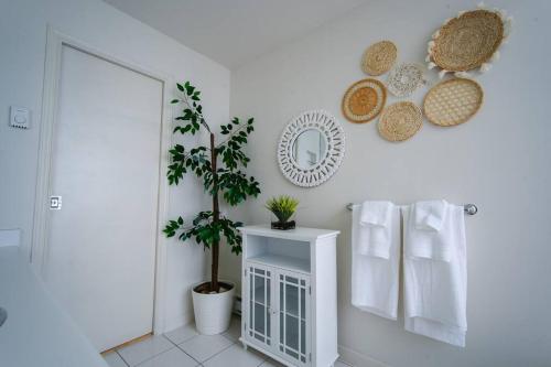 a bathroom with a plant and a mirror and towels at Heart of Downtown King Suite/Parkng/Pool/Gym/Sauna in Vancouver