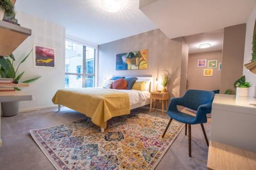 a bedroom with a bed and a blue chair at Heart of Downtown King Suite/Parkng/Pool/Gym/Sauna in Vancouver