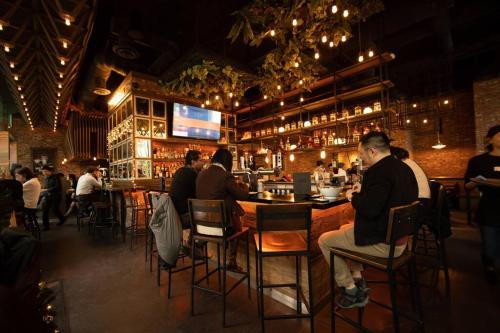 a group of people sitting at a bar in a restaurant at Heart of Downtown King Suite/Parkng/Pool/Gym/Sauna in Vancouver