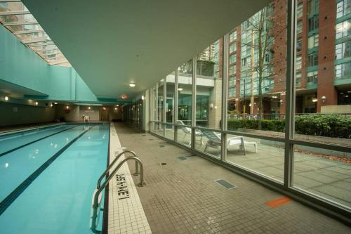 a large swimming pool in a building at Heart of Downtown King Suite/Parkng/Pool/Gym/Sauna in Vancouver