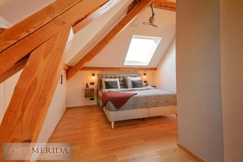 a attic bedroom with a bed and a skylight at Loft Merida - Designer Apartment with Large Bathtub in Butgenbach