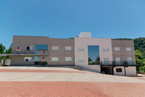 a large building with a brick sidewalk in front of it at Hotel Bergozza in Rio do Sul