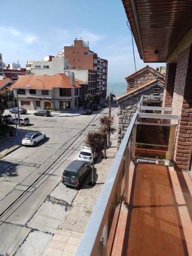 un balcón de un edificio con coches aparcados en una calle en La Perla en Mar del Plata