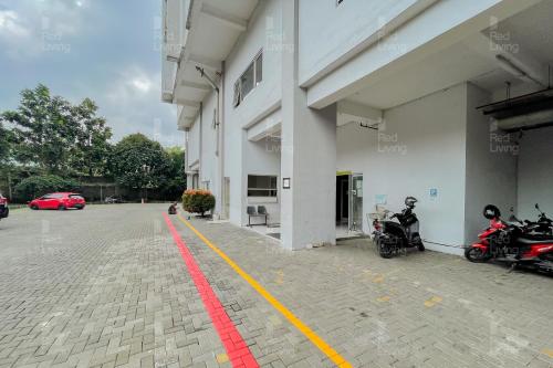 a parking lot with two motorcycles parked in front of a building at RedLiving Apartemen Easton Park Jatinangor - Rajes Room in Sumedang
