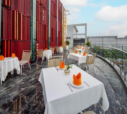 a restaurant with white tables and chairs on a balcony at Eden Star Saigon Hotel in Ho Chi Minh City