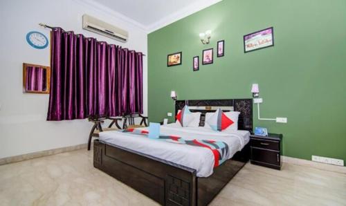 Schlafzimmer mit einem großen Bett und roten Vorhängen in der Unterkunft FabExpress Ashray in Noida