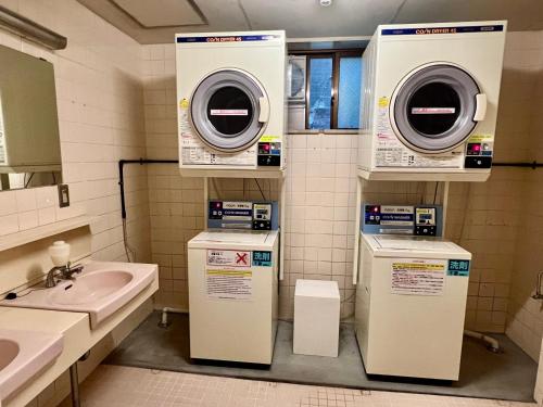 een badkamer met een wastafel en een wasmachine bij Ryokan Kosen Kazeya Group in Nara